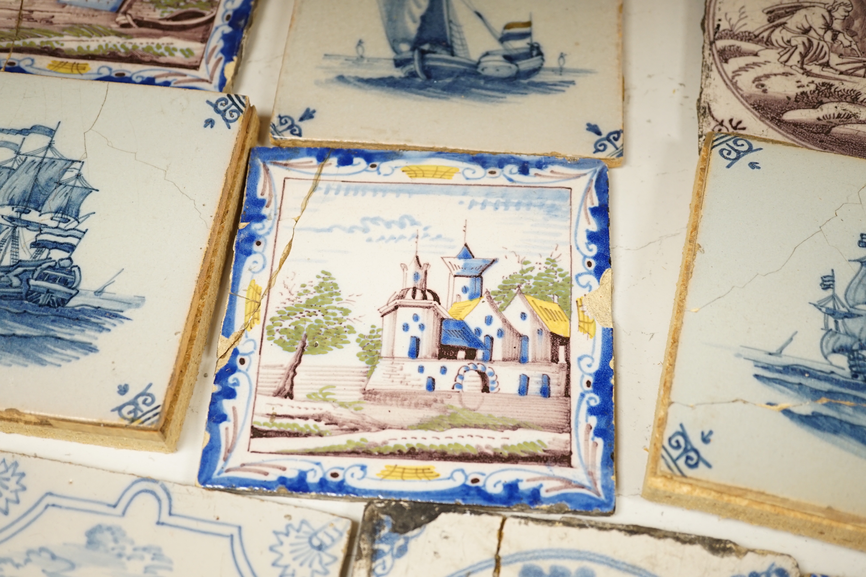 A group of Delft tiles including two polychrome examples and three decorated with ships, 18th/19th century, approximately 12.5cm x 12.5cm (a.f.)